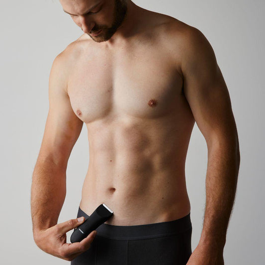 Man holding trimmer near groin ready to shave pubic hair quickly
