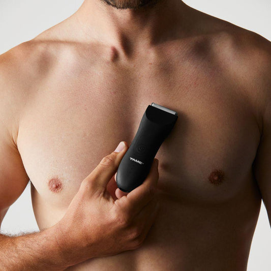 Man manscaping, removing body hair with a trimmer